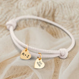 Personalisiertes PU-Lederarmband mit 2 gravierten Gold-Herz-Anhängern mit mit Initialen in Creme - gefertigt von Love & Faith